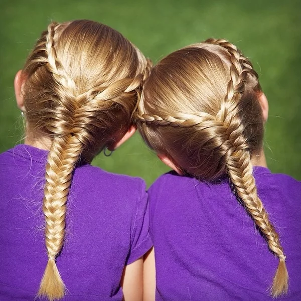 Zwillinge mit blondem Haar gut geflochtene Zöpfe Mädchenfrisuren für die Schule