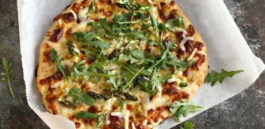 leckere Pizza mit grünen Spargeln, Käse und Rucola