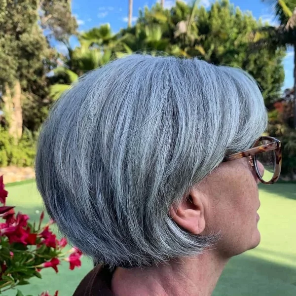 Frisuren für graue Haare Bob Trendfrisuren für Frauen ab 60 Seitenansicht Frau mit Brille