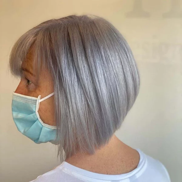 Frisuren für graue Haare ab 60 A Line Bob Pony Frau mit Mundschutzmaske