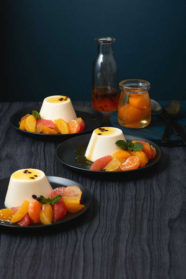 Panna Cotta mit Mandarinen Raffinesse auf Tellern serviert mit Mandarinenstücken verziert