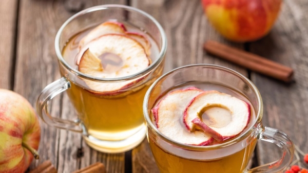 Warme Winter-Drinks Apfelpunsch mit Schuss mit trockenen Apfelscheiben im Glas