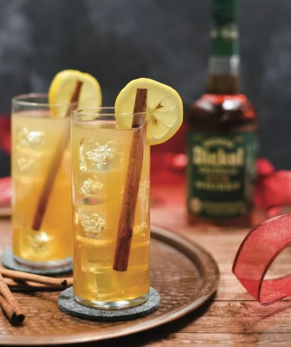 Warme Winter-Drinks Holiday Sour ein Wintergetränk mit Whiskey frischer Zitronensaft Apfel-Honig-Sirup dazu