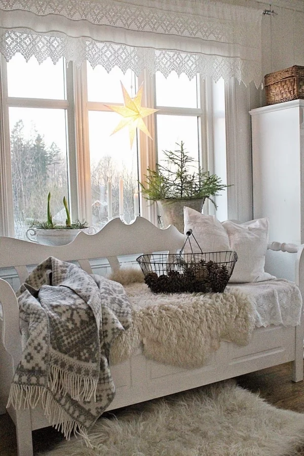 Winterdeko im Wohnzimmer Fenster mit Stern und Grün dekorieren Fensterecke Sofa weiche Kuscheldecken Pelzdecke Pelzteppich