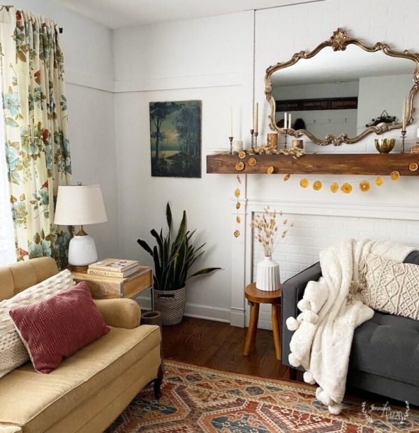 Winterdeko im Wohnzimmer im rustikalen Stil viele warme Farben Sofa Gardinen Bild Spiegel