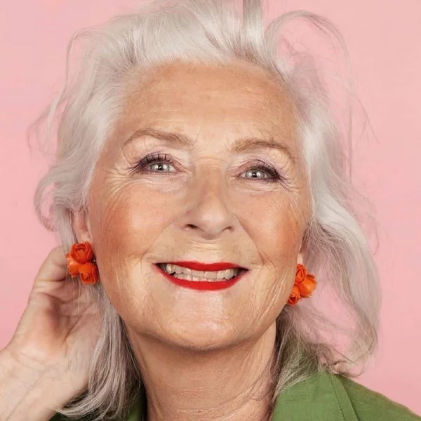 graue Haarfarbe moderen ältere Dame mit langes grauen Haar orange Ohrringe 