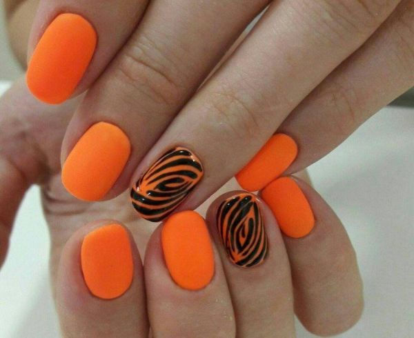 kurze Fingernägel in greller orangenen Farbe