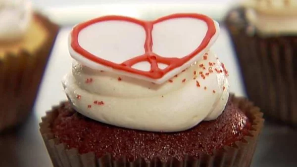 Herzhaftes zum Valentinstag in Herzform Muffin mit weißer Creme garniert Herz aus roter Speisefarbe