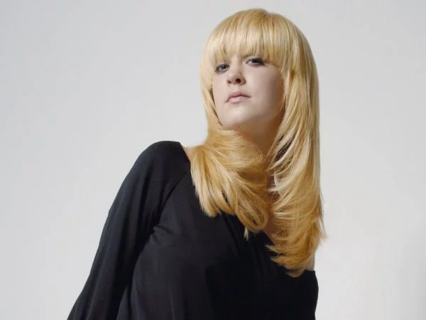 junge Frau mit langem blondem Haar mit Razor Cut asymmetrisch gestylt 