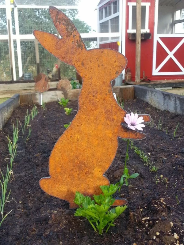 Osterdeko für draußen DIY Ideen ein Hase im Garten hält eine Blume