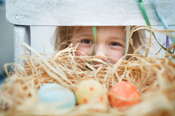 Osterdeko für draußen DIY Ideen kleines Mädchen im Hintergrund ein Nest bunte Eier