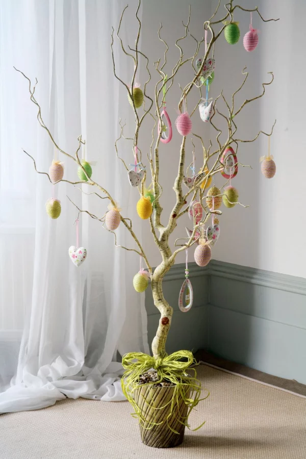 Osterdeko für draußen Osterbaum im Topf im Haus neben dem Fenster mit vielen bunten Eiern dekoriert