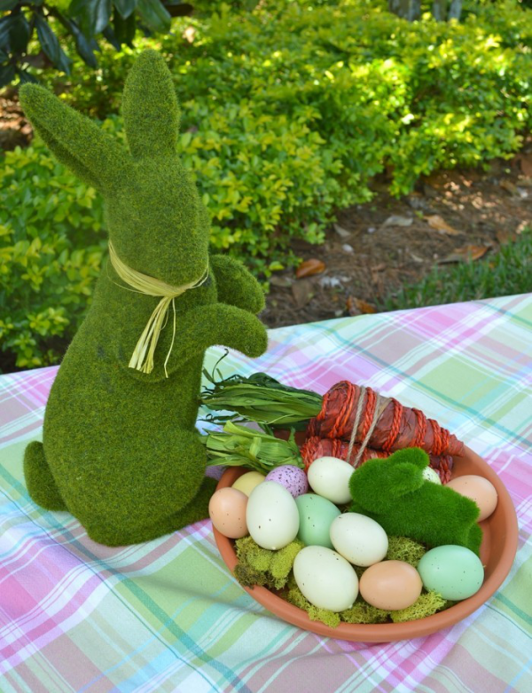 Osterdeko für draußen gedeckter Tisch im Freien Hase aus Moos Schale mit bunten Eiern Möhren