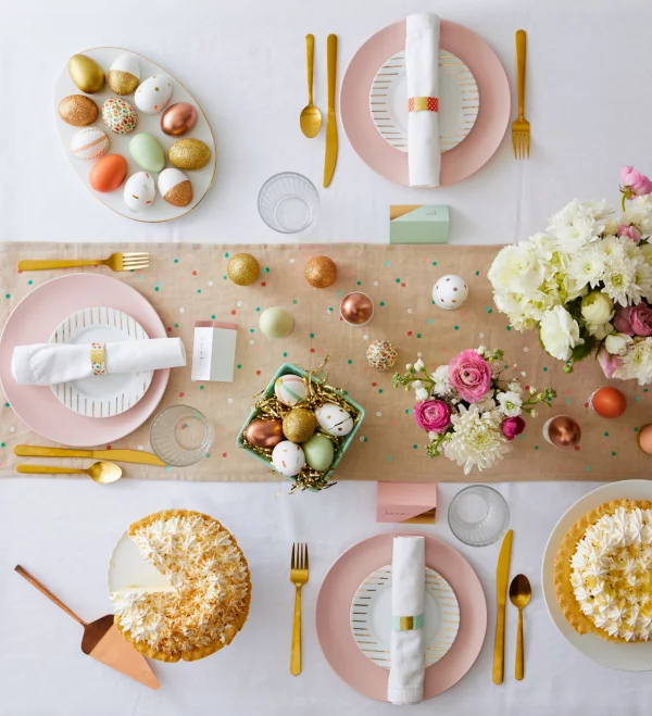 Ostertafel dekorieren goldschimmernde Ostereier als Akzente auf dem festlich gedeckten Tisch