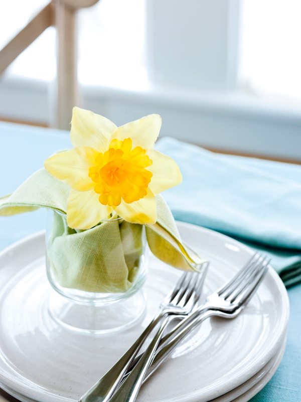 Ostertafel dekorieren weißes Geschirr Glas gelbe Narzisse hellgrüne Serviette weniger ist mehr