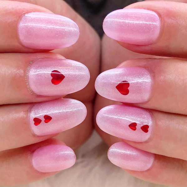 Romantische Maniküre zum Valentinstag schönes Nageldesign rosa mit kleinen roten Herzen