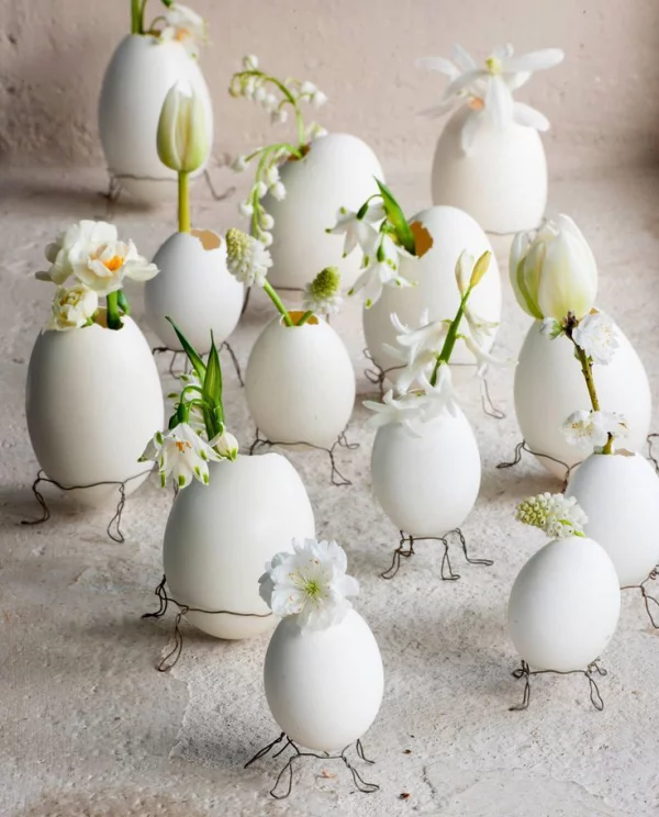 Tischdeko zu Ostern ausgeblasene Eier in kleine Vasen verwandeln weiße Blumen darin stecken