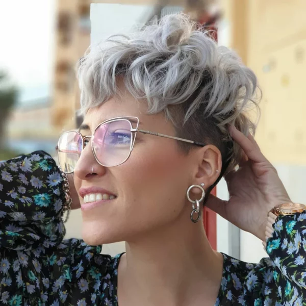 junge Frau mit Kurzhaarfrisur mit Wellen und Undercut mit trendiger Brille 