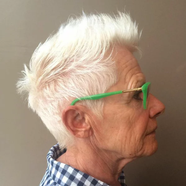 ältere Frau mit kurzem Punky-Pixie Cut und grüner Brille