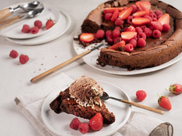 Schokokuchen ohne Mehl mit frischen Erdbeeren eine Kugel Eis vergeht das Dessert auf der Zunge
