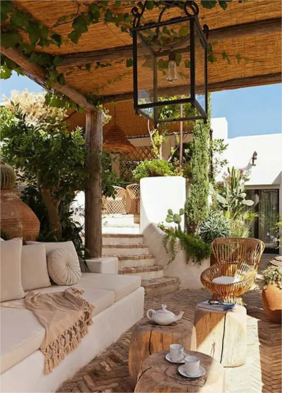 mediterraner Außenbereich raue Naturmaterialien Stein Beton Treppen weiße Sitzmöbel Überdachung aus Holz