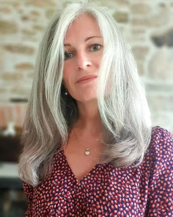 Frau über 50 mit grauen, langen Haaren und blauen Augen 