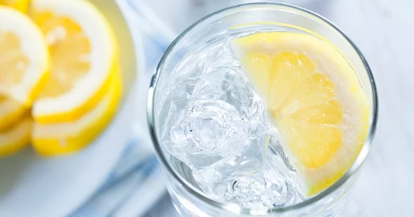 Am Abend Zitronenwasser trinken vor dem Schlafengehen ein Glas mit Eis und Zitronensaft 