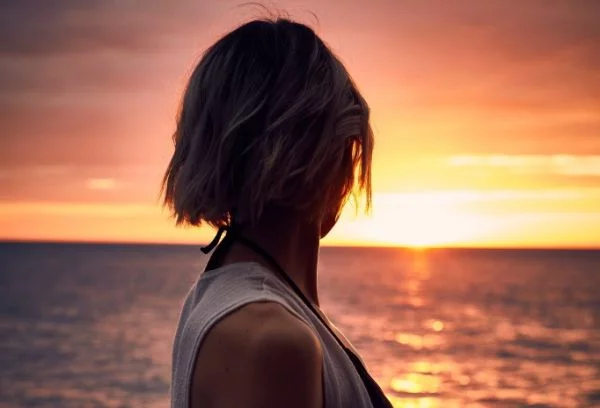 Frau vor dem Sonnenaufgang - die Beach Waves Bob Frisuren sind im Sommer ein Hit