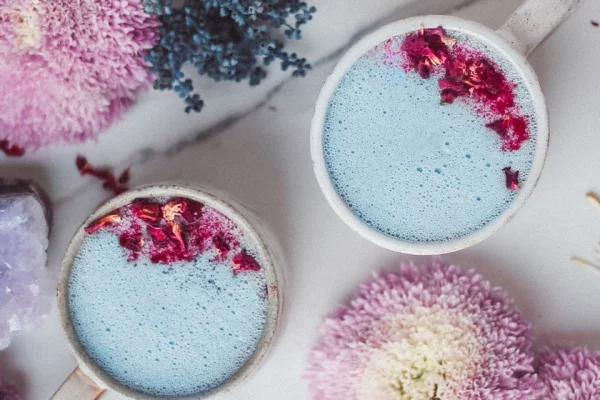 Moon Milk blaues Getränk mit getrockneten Blüten verzieren