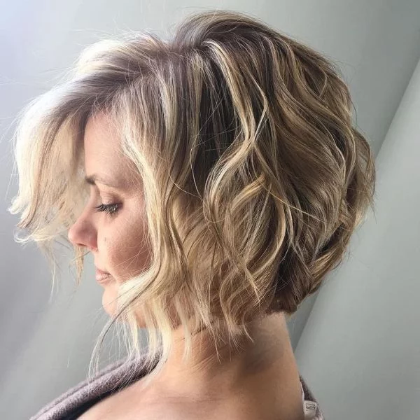 Curly Bob - junge Frau mit blondem kinnlangem Haar mit lässigen Stranwellen 
