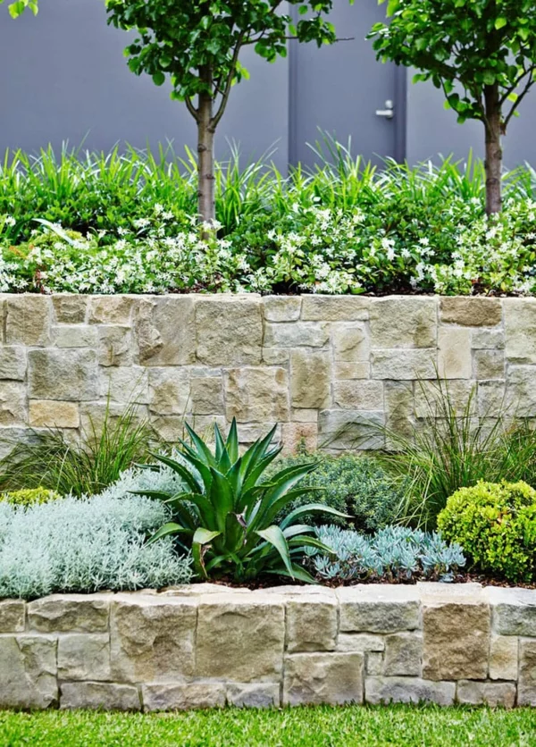 Gartenbeete mit Steinmauern und grünen Pflanzen