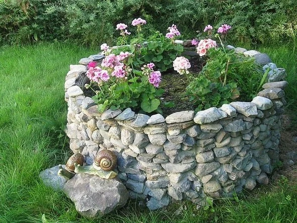 Gartenbeet mit Steinen und dekorative Schnecken
