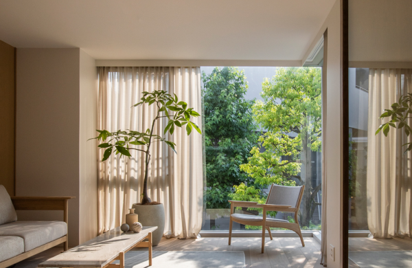Japanisches Design Wohnraum in hellen Farbtönen deckenhohe Fenster Blick zum Garten keine Grenze zwischen drinnen und draußen