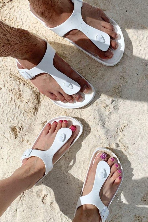 weiße Sandalen im Sommer am Strand tragen