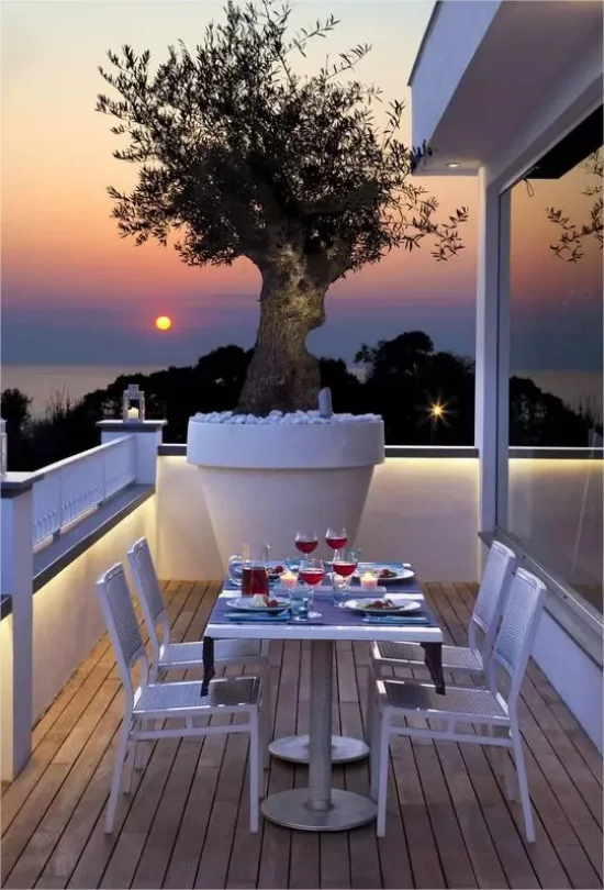 Gartenmöbel aus Metall auf der Terrasse gedeckter Tisch Sonnenuntergang am Meer sehr romantisch