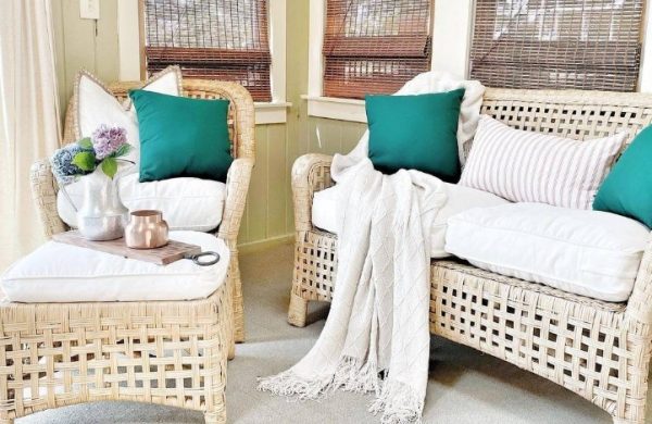 Verglaste Veranda warm gemütlich einladend helle Möbel weiße Polsterkissen türkisfarbene Wurfkissen