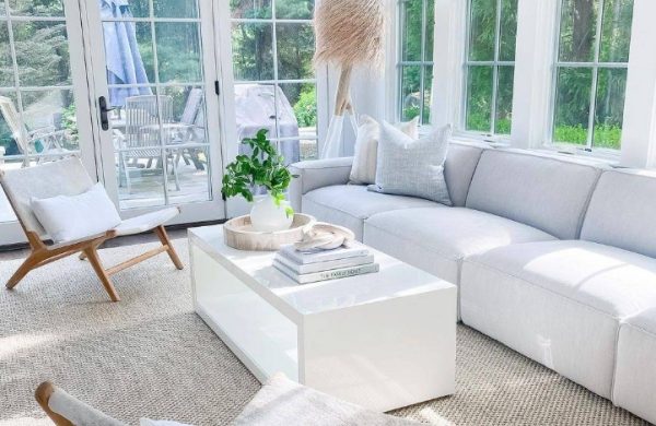 Verglaste Veranda weiße Polstermöbel helle einladende Atmosphäre Ort der Ruhe Entspannung