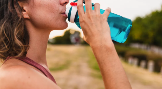 Appetit zuegeln bei Hitze uSport viel Wasser trinken gut hydriert bleiben junge Frau beim Trinken