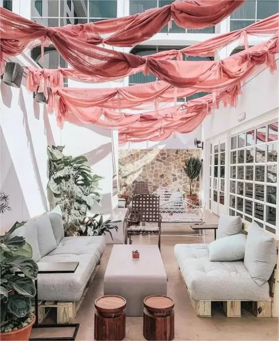 Feminine Outdoor-Bereiche Sitzmöbel aus Paletten hellgraue Polsterung rosa Segel