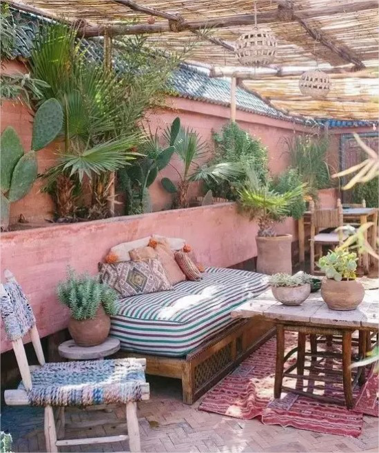 Feminine Outdoor-Bereiche Vintage Stil Möbel aus altem Holz rosa Wand gruene Topfpflanzen