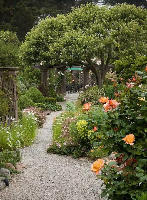 Gartenwege mit Kies Naturgarten Rosen rechts viel Gruen ansprechender Look
