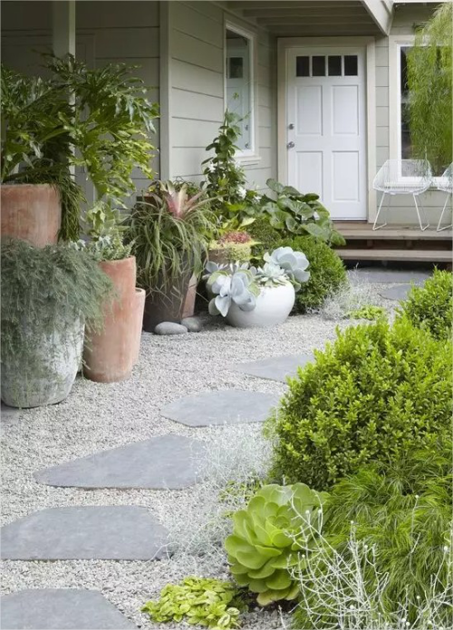 Gartenwege mit Kies große Trittplatten aus Stein alte Kuebel viele Pflanzen