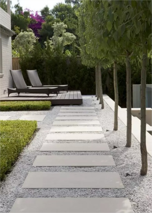 Gartenwege mit Kies perfekte Gestaltung sehr modern zwei Liegestuehle auf einem Podest