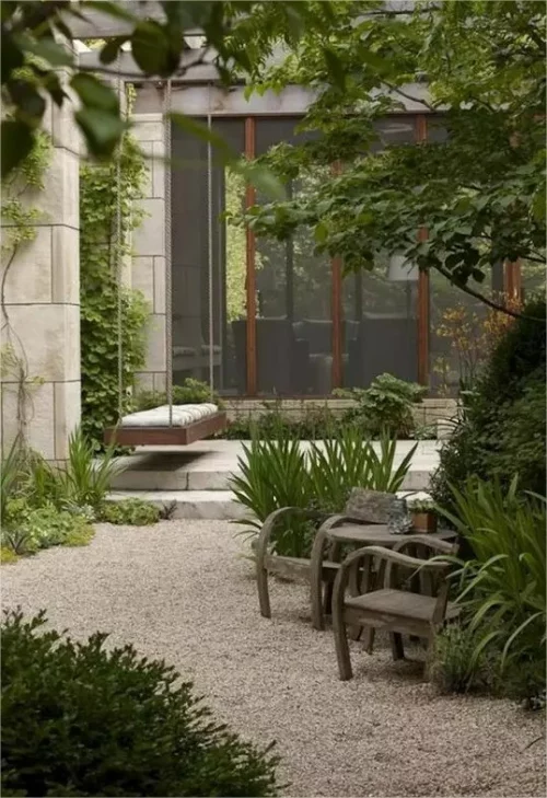 Gartenwege mit Kies rustikale Gartenstuehle Tisch komplettieren den Look