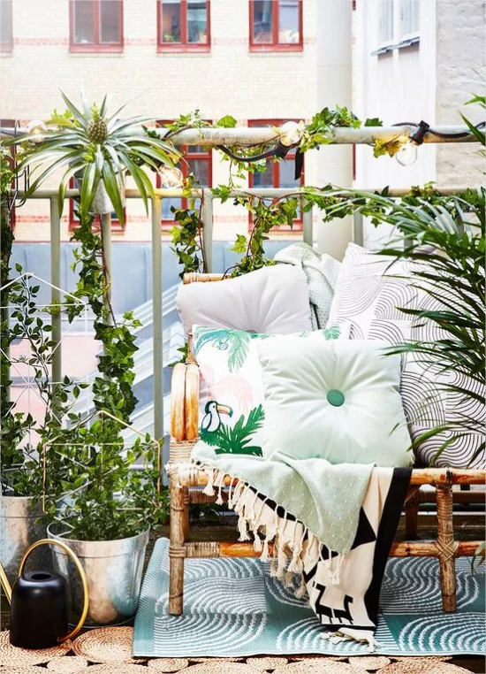 Gestaltungsideen fuer Balkon gruene Kuebelpflanzen weiche Kissen das romantische Gefuehl verstaerken