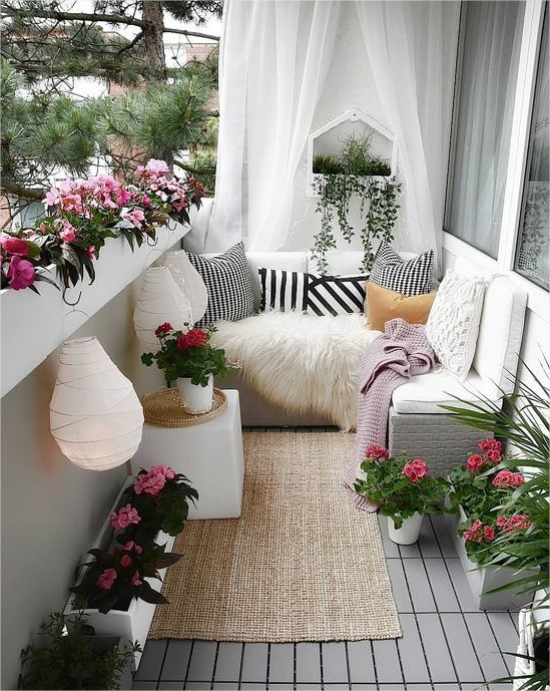 Gestaltungsideen fuer Balkon romantische Note Laternen Blumen weiße Vorhaenge weiche Textilien
