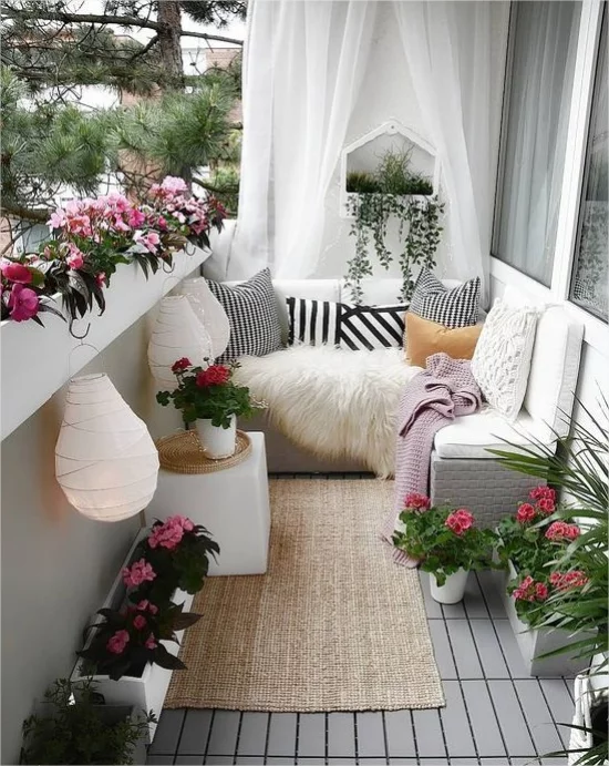 Gestaltungsideen fuer Balkon romantische Note Laternen Blumen weiße Vorhaenge weiche Textilien