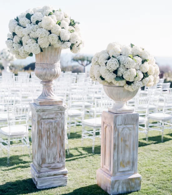 Hochzeitsdeko mit Hortensien weiße Blueten auf Marmorsaeulen Gaeste willkommen heißen