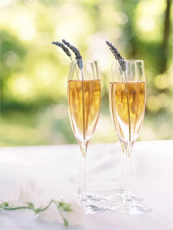 Hochzeitsdeko mit Lavendel Sektglaeser gefuellt Lavendelstiele auf Familienglueck trinken
