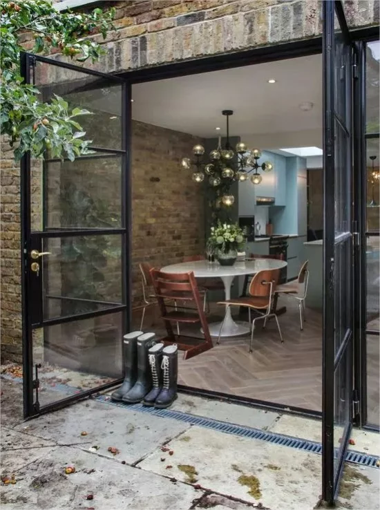 Indoor-Outdoor-Kuechen Glastueren Steinplatten Ziegelwand rustikaler Stil